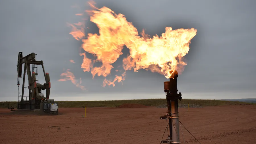 A flare burns natural gas at an oil well Aug. 26, 2021, in Watford City, N.D. [ MATTHEW BROWN | AP ]