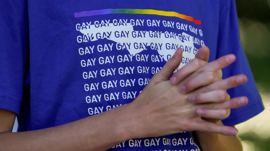 A person wears a shirt featuring the word “gay” over a map of the state of Florida during the raising of the Pride flag at city hall to mark the start of Pride Month on June 1 in St. Petersburg. [ MARTHA ASENCIO-RHINE | Times ]